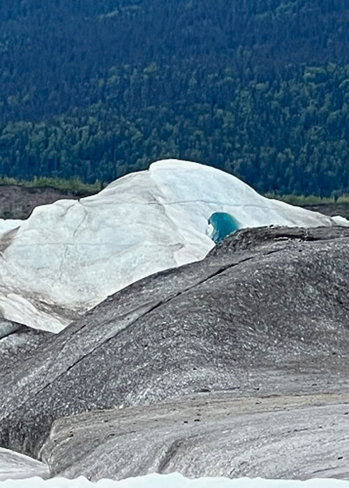 Glacier with a hole in it, cloudy sky above