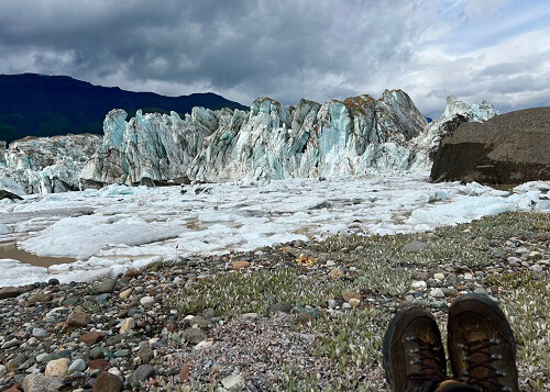 Looking at glacier wall, shoes at bottom right foreground