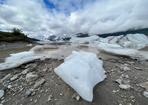 Chunk of ice at edge of glacier lake with chunks of ice in it