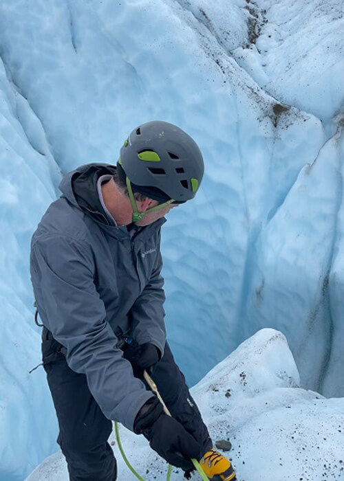 Mark Loftin on a glacier, lowering down a slant with a rope