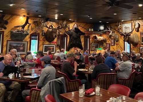 Inside a restaurant in Alaska busy with patrons and animal heads on the walls