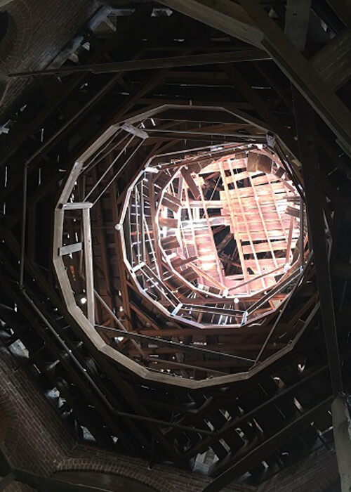 Looking up a circular spire inside the unfinished Longwood Mansion, interior construction boards visible.