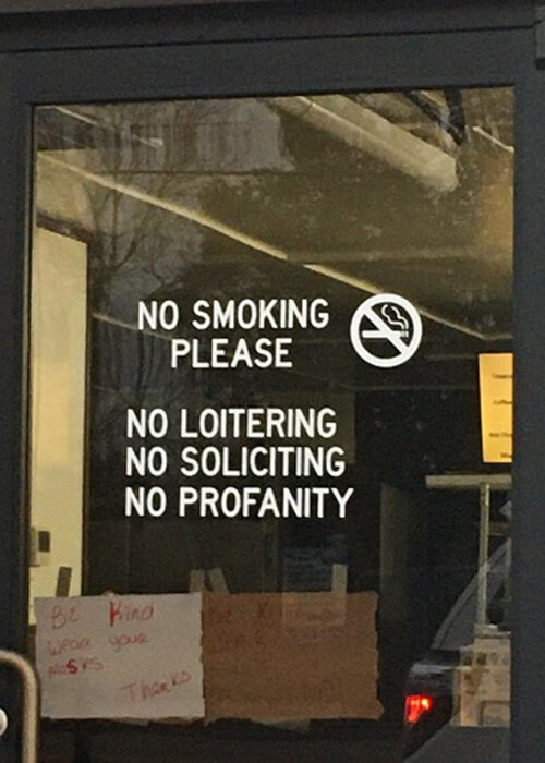 Sign on window that reads "No Profanity" at a donut shop.