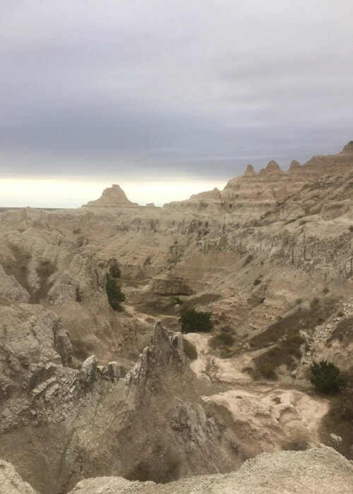 Eroded light tan rock and hill structures with random ridges and jagged edges.