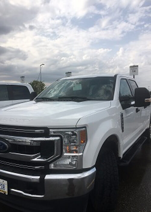 Large white pickup truck with cloudy sky above.