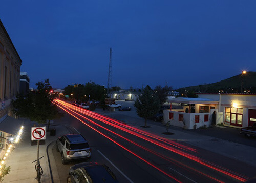 Night photo looking down on street with red light light streaks from an extended camera exposure.