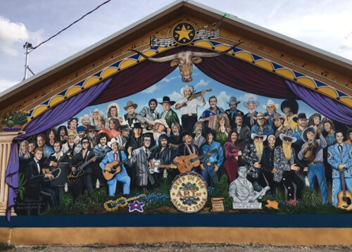 Giant mural of various rock and country stars, resembling The Beatles Sgt. Pepper's album cover.