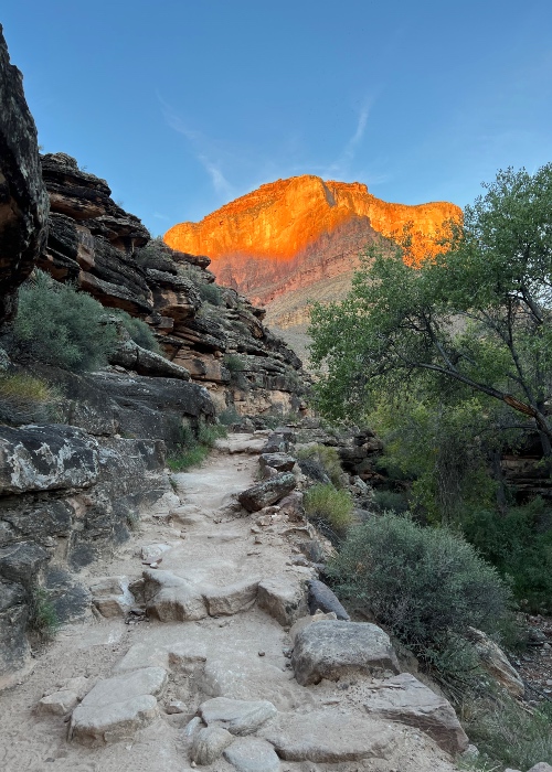 Bright Angel hiking trail in Grand Canyon, looking up trail to sun bleached orange monolith