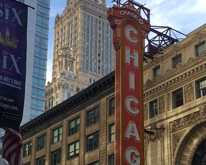 Downtown Chicago buildings during the daytime with a close-up of the Chicago Theater sign.