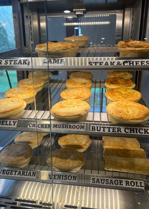 Close-up of a food display case containing three wire racks of various types of breakfast pastries.